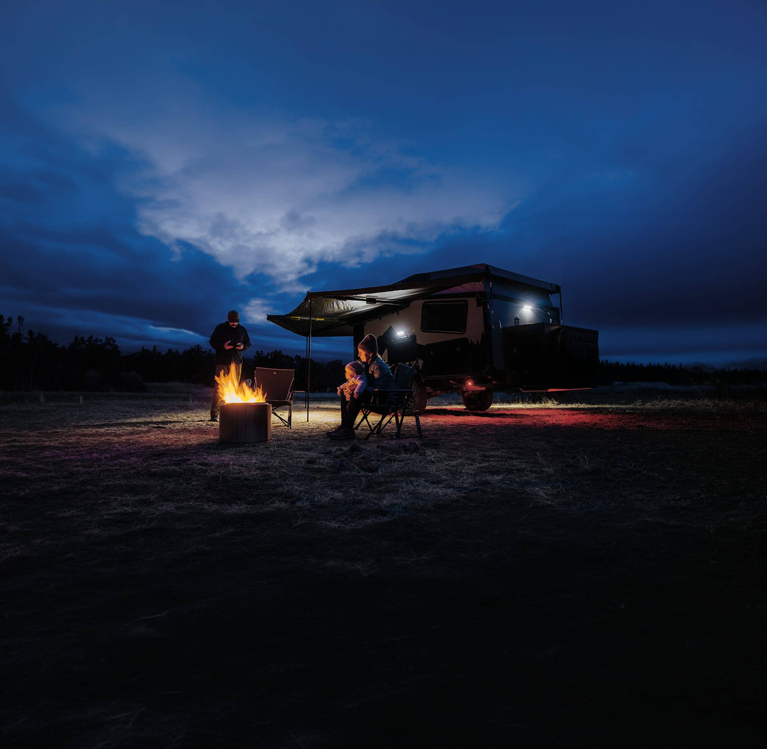 Camping-car familial garé la nuit avec des lumières scintillantes