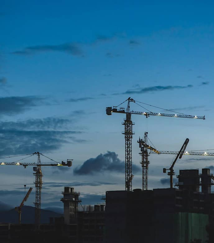 Grues de chantier sur un site de construction au crépuscule