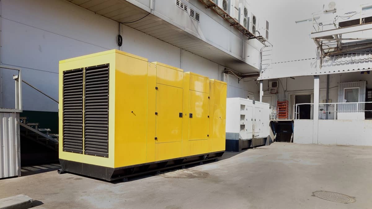 Grand générateur jaune situé dans une cour industrielle