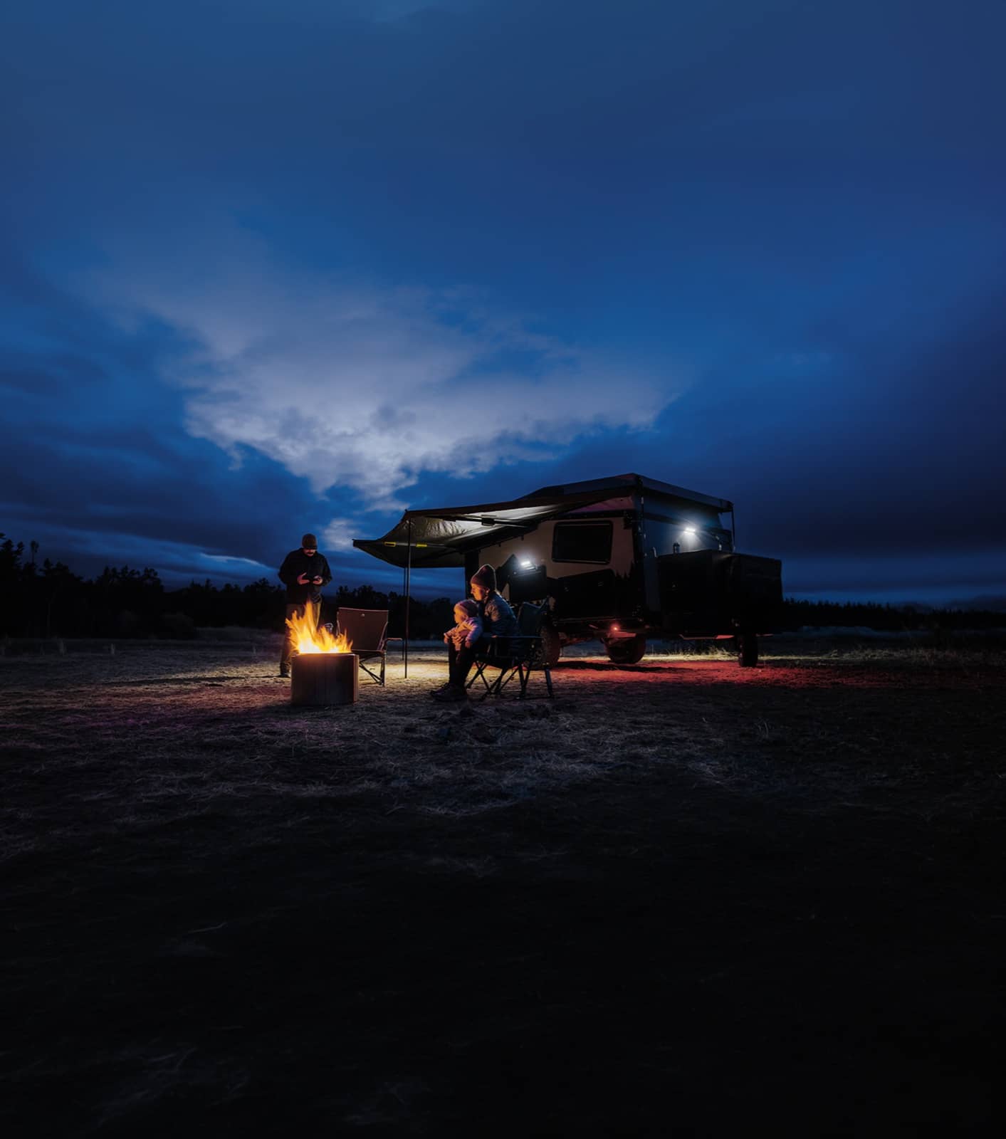 Camping-car familial garé la nuit avec des lumières scintillantes