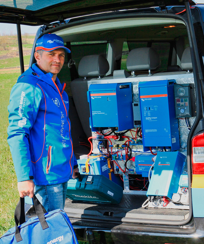 Professionnel de Victron se tenant à côté d’un équipement Victron à l’arrière d’une voiture